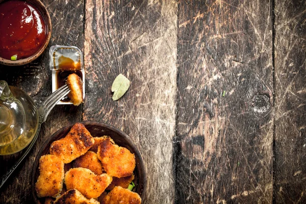 Stock image Chicken nuggets in a bowl with tomato sauce.