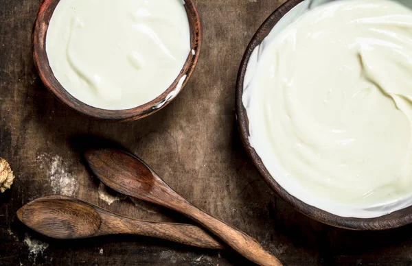 Natuurlijke yoghurt in een kom met een lepel. — Stockfoto