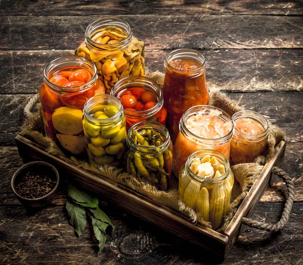 Preserves food with vegetables and mushrooms on an old tray.