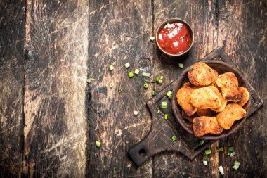 Bir kase domates soslu tavuk nuggets.