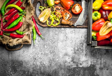 Bir eski kesme tahtası üzerinde dilimlenmiş tatlı biber.