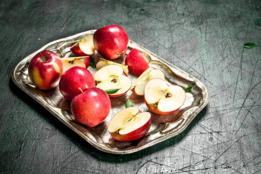 Yaprakları ile çelik bir tepsi üzerinde kırmızı elmalar.