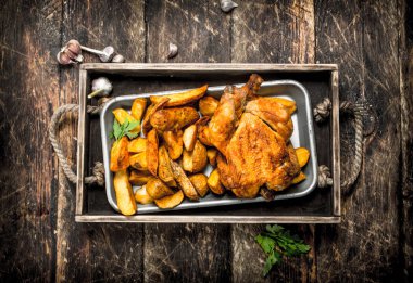 Bir tepsi üzerinde tavukla patates kızartması.