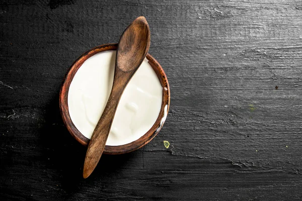 Natuurlijke melk yoghurt in een kom met een lepel. — Stockfoto