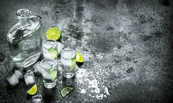 Vodka com pedaços de limão e cubos de gelo . — Fotografia de Stock