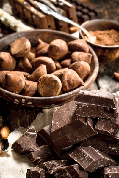 Different types of chocolate, cocoa powder and pieces of dark chocolate.