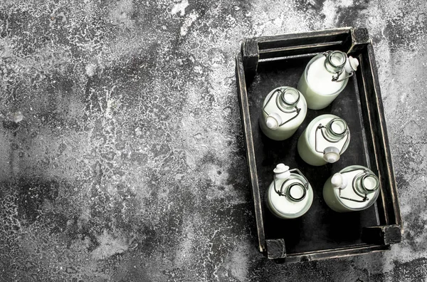 Botellas de leche fresca en una caja vieja . — Foto de Stock