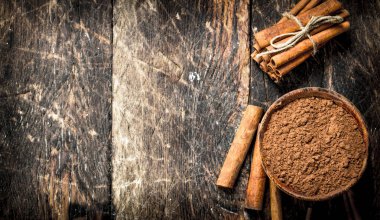 Zemin Tarçın bir kase. Ahşap arka plan üzerinde.