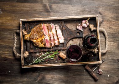 Sığır eti kırmızı şarap ile ızgara. Ahşap bir masaya.