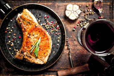 Kırmızı şarap ile ızgara domuz biftek. Ahşap arka plan üzerinde.