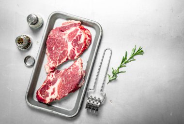 Baharat ile taze çiğ Dana biftek. Rustik arka plan üzerinde.