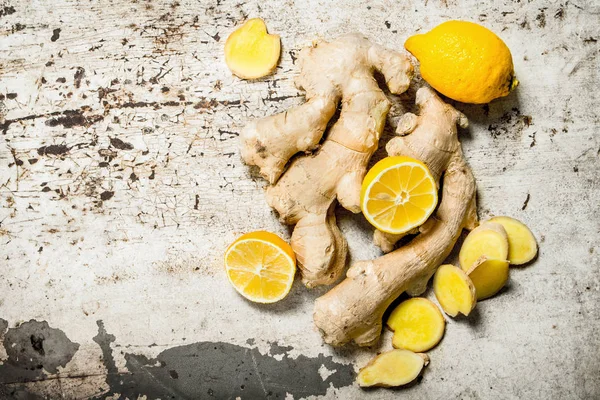 Fresh ginger with lemons. On rustic background.