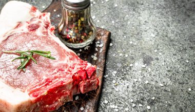 Çiğ domuz biftek otlar ve baharatlar ile. Rustik arka plan üzerinde.