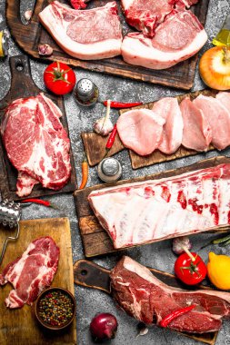 Farklı türde Çiğ domuz eti ve baharat ve otlar ile sığır eti. Rustik arka plan üzerinde.