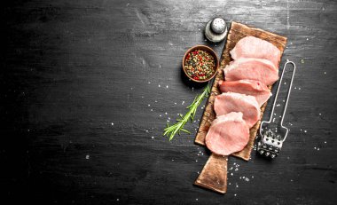 Çiğ domuz biftek baharat ve otlar ile. Siyah kara tahta.