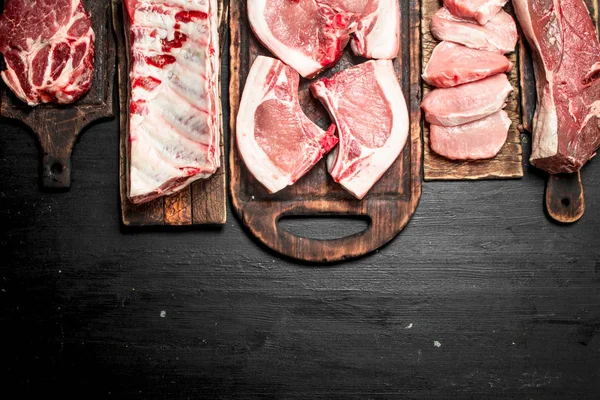 不同种类的生猪肉和牛肉 在黑色黑板上 — 图库照片