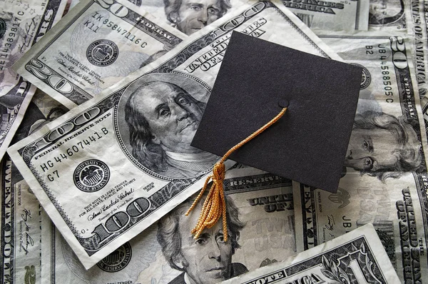 Graduation cap on assorted money — Stock Photo, Image