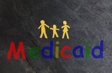 Dokulu yüzey üzerine renkli Medicaid metni olan üç kişilik kağıt ailesi                              