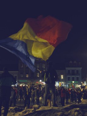 Protestocu sallayarak Romanya bayrağı