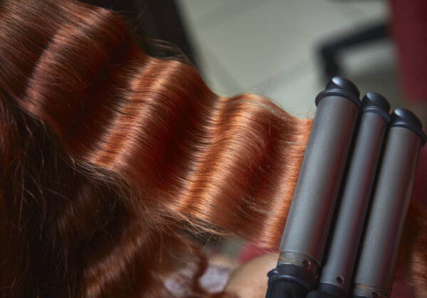Red hair curled with triple barrel curling  iron