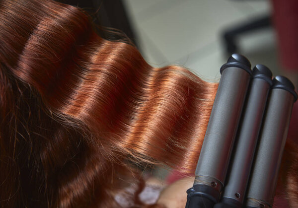 Red hair curled with triple barrel curling  iron