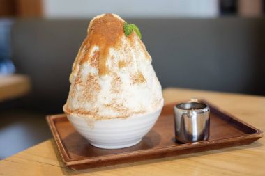 Çikolata soslu beyaz kase hizmet iki sesi kakigori (Japon kesilmiş buz tatlı lezzet Çikolata tozu ile).