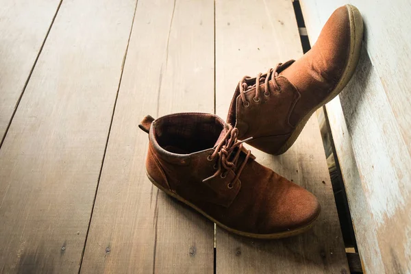 Ahşap zemin üzerinde kahverengi deri ayakkabı.