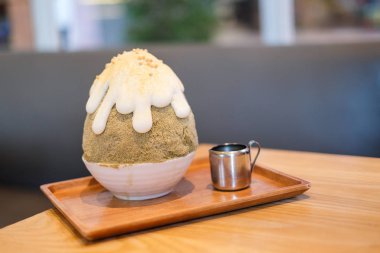 Hojicha kakigori (Japon kesilmiş buz tatlı lezzet beyaz krema ile) hizmet Kuromitsu soslu beyaz kase.