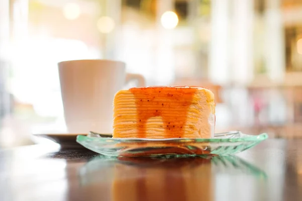 Parte de la torta de crepe rematada con salsa de fresa servir en plato claro y leche fresca caliente en vaso de postre fondo casero o textura - concepto de dieta saludable . — Foto de Stock