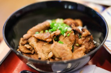 Pirinç ızgara domuz teriyaki ve üst Japon yemekleri arka plan veya doku için kırmızı tepsi altında siyah plastik kapta soğan ile.