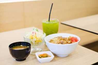 Pirinç ızgara domuz teriyaki ile gıda kümesi oluşur, taze soğan ve havuç üst beyaz kase üzerinde tofu çorbası (Miso çorbası), domates, lahana ve Mısır salata ve yeşil çay - Japon gıda kavramı ile hizmet.