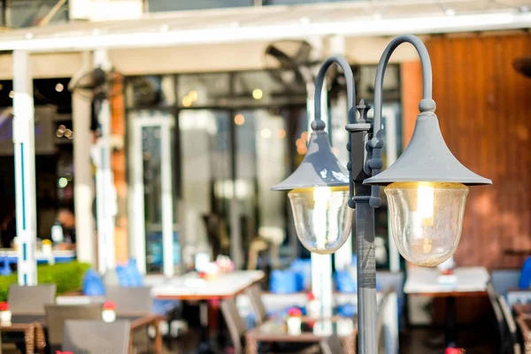 Il lampione vintage (lanterna) brilla vicino al ristorante all'aperto per sfondo o consistenza . — Foto Stock