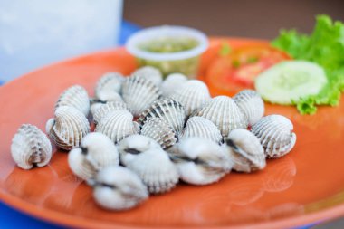 Deniz ürünleri sos, domates ve salatalık için arka plan ile portakal yemek taze istiridye hizmet.