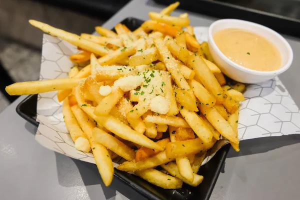 French fries with powder cheese and mayonnaise sauce serve on black plate for food background. — Stock Photo, Image