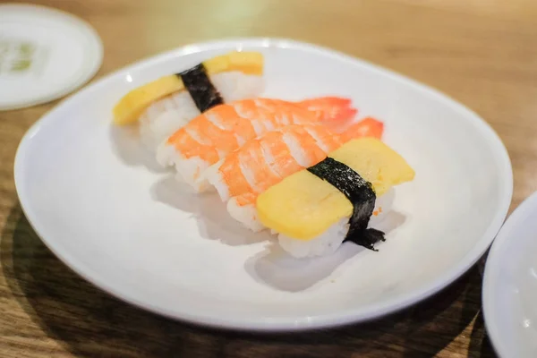 Sushi de camarões (Amaebi) e omelete laminado japonês (tamagoyaki) com topo de algas no arroz servem no prato branco - fundo de comida japonesa ou textura . — Fotografia de Stock
