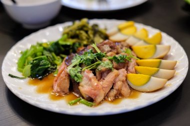 Demlenmiş Domuz eti bacak serpin kişniş ile hizmet split haşlanmış yumurta, Çince lahana ve beyaz plaka - gıda arka plan veya doku, yağ kavramı üzerinde turşu ekşi sebze.