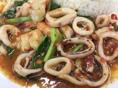 Karıştırın-kızarmış kalamar, karides ve fesleğen (baharatlı, Chili Taste) ev yapımı arka plan veya doku için beyaz plaka üzerinde hizmet-Tayland gıda konsepti.