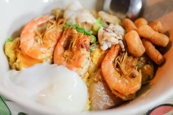 Fried rice noodle with chicken, soft-boiled egg and seafood serve on white bowl. — Stock Photo, Image