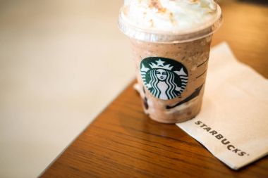 Bangkok, Tayland - 30 Ocak 2018: Buz Frappuccino (ve Frappe Cappuccino) doku veya kağıt ve Starbucks kahve işareti ile kahverengi masa.