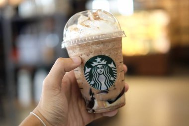 Bangkok, Tayland - 30 Ocak 2018: Arka plan bulanık ve Starbucks kahve işareti ile buz Frappuccino (ve Frappe Cappuccino) tutan el.