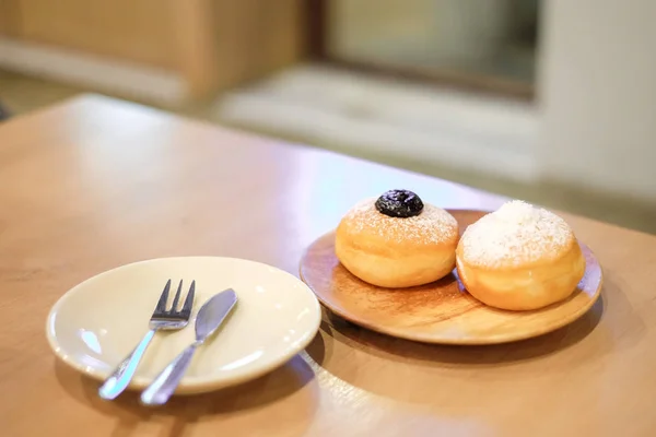 Donut de arándano y Donut de coco con polvo sirven en placa de madera con cuchara y tenedor establecido en la mesa - Panadería casera & Concepto de postre . — Foto de Stock