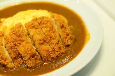 Baharatlı gevrek Domuz pirzola omlet köri hizmet beyaz tabak üzerinde Japonca veya Asya gıda arka plan veya doku için.