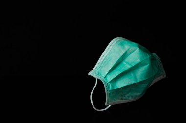 Toz (PM 2,5), hastalık (Coronavirus veya COVID-19) önleme amaçlı cerrahi maske (Doktor) siyah arkaplanda izole edildi).
