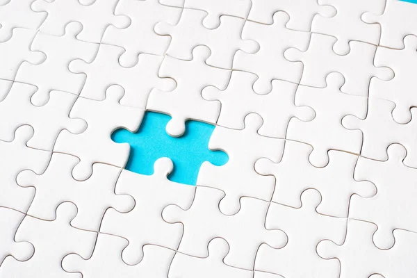 White jigsaw puzzle on blue background (blue gap) - idea solution concept.
