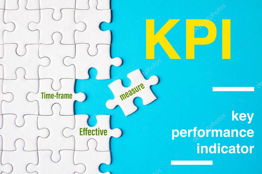 Many white jigsaw puzzle and KPI (key performance indicator) word on blue background - idea solution concept.