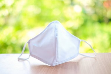 Tozu önlemek için doğa arka planında izole edilmiş bez beyaz maske (PM 2.5),