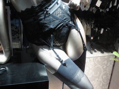 HAMBURG, GERMANY - CIRCA NOVEMBER 2016: Aubade brand store with mannequins wearing lingerie and suspender belt stockings - detail of a pair of black stockings clipart