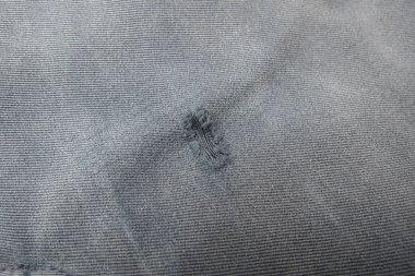 Gri kumaş yüzeyi ile yamalı delik arka plan olarak yararlı