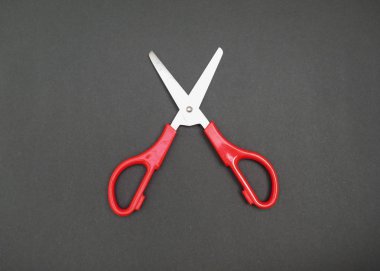 Siyah arka plan üzerinde kırmızı makas