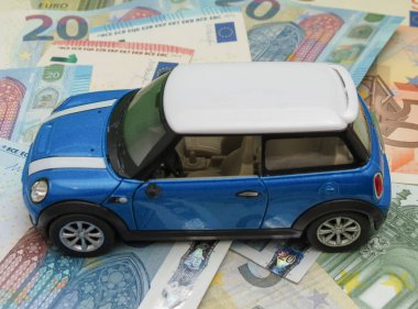 Oxford, İngiltere - Mayıs 2017 yaklaşık: Çin, çocuk oyuncak 2014, yaklaşık olarak Eur Notlar arka plan üzerinde üretilen hafif mavi Mini Cooper araba (2013 sürümü) minyatür gösterimi